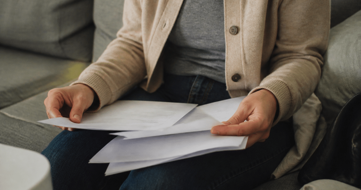 Personne assise tenant documents pret bancaire et certificat maladie