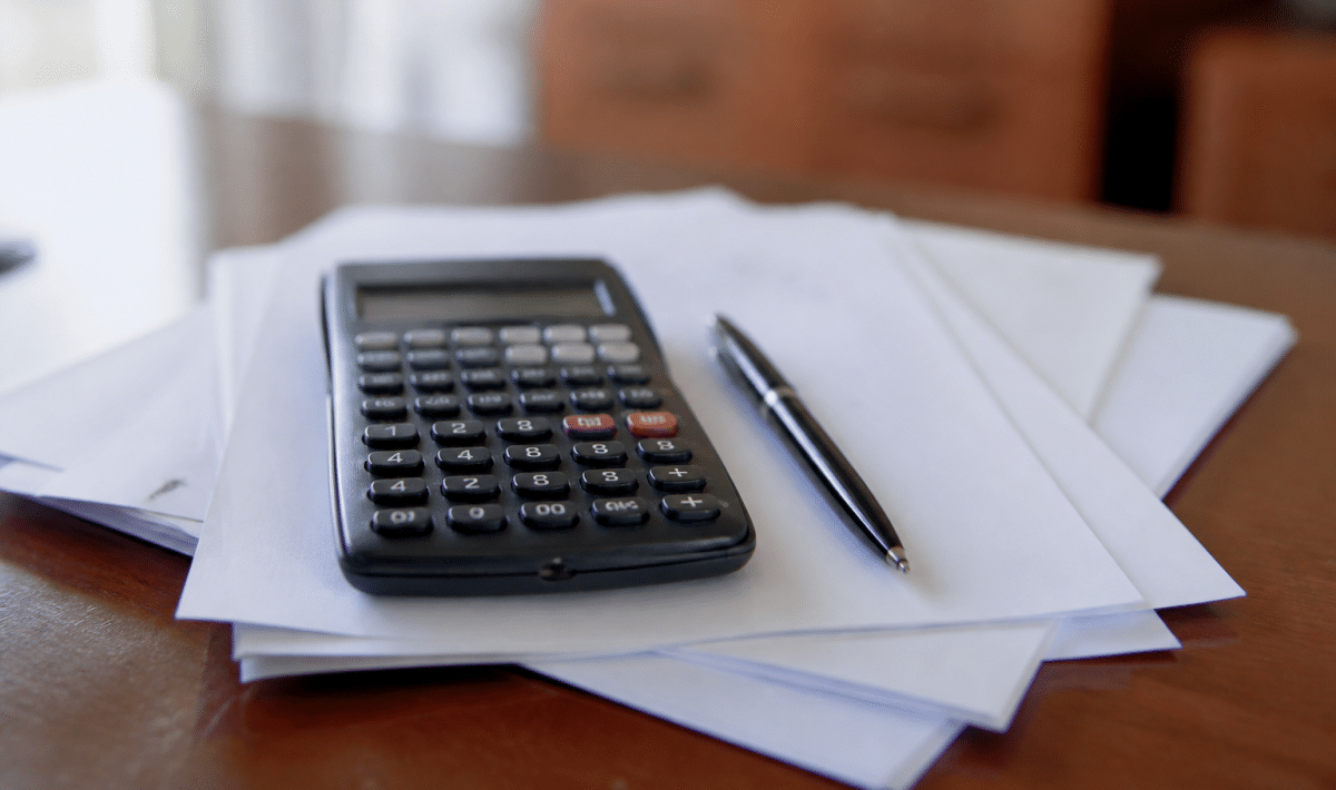 Calculatrice posee sur documents hypothecaires avec stylo noir