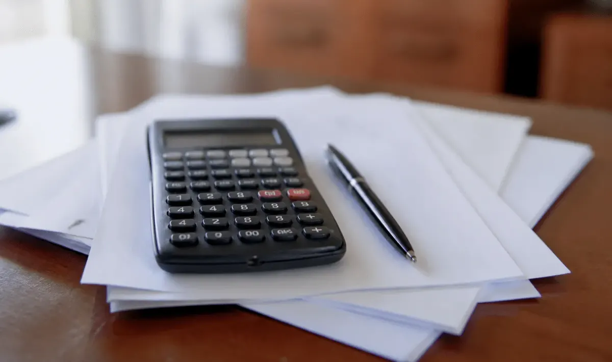 Calculatrice posee sur documents hypothecaires avec stylo noir
