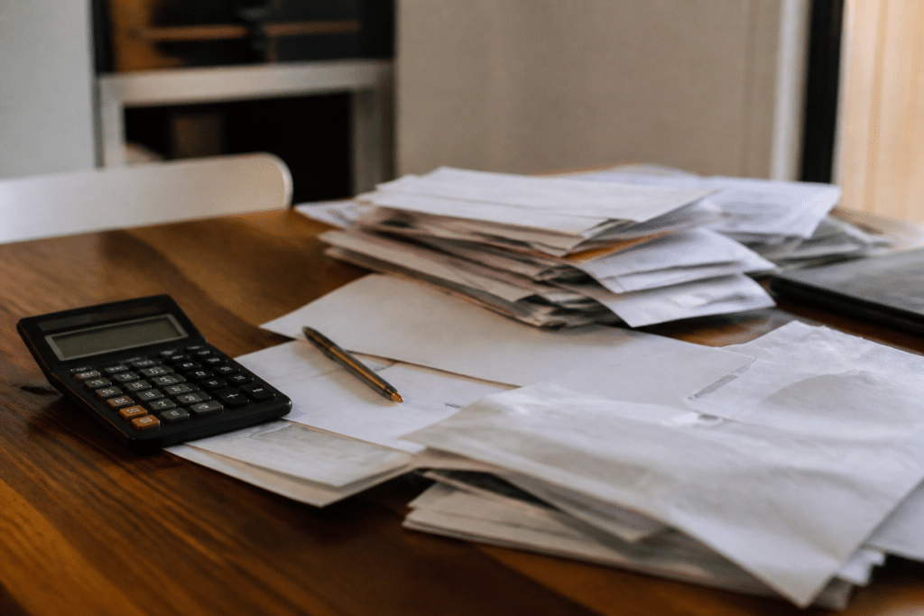 Documents financiers avec calculatrice et factures immobilières empilées