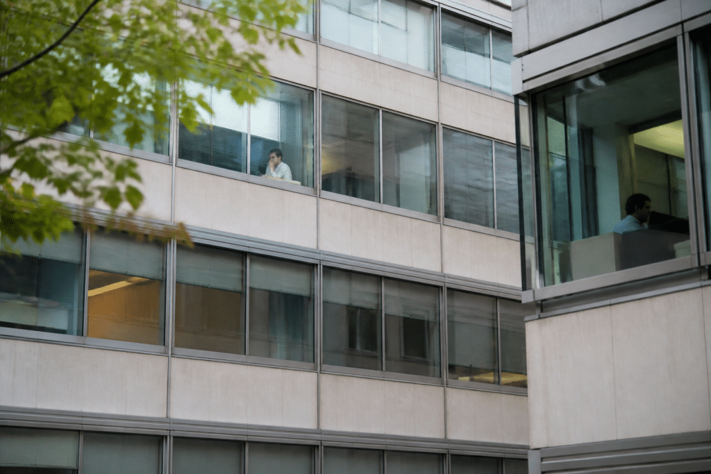 Immeubles de bureaux et commerces avec locataires visibles aux fenêtres