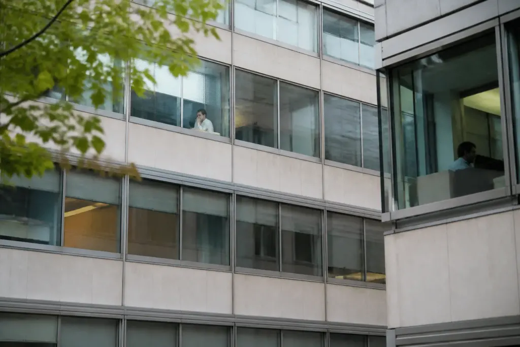 Immeubles de bureaux et commerces avec locataires visibles aux fenêtres