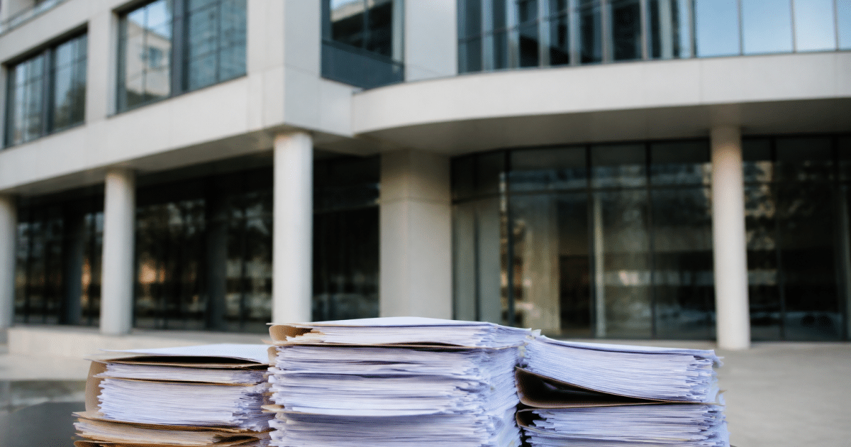 Immeuble moderne avec documents financiers empilés devant