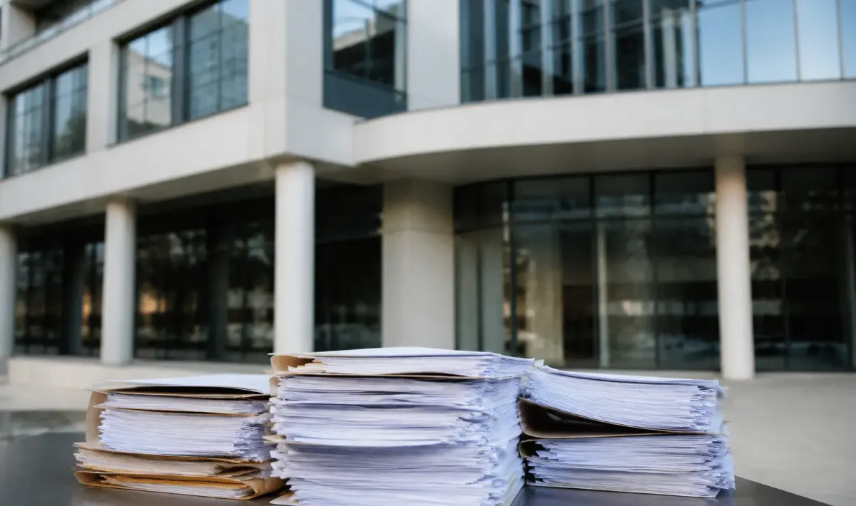 Immeuble moderne avec documents financiers empilés devant