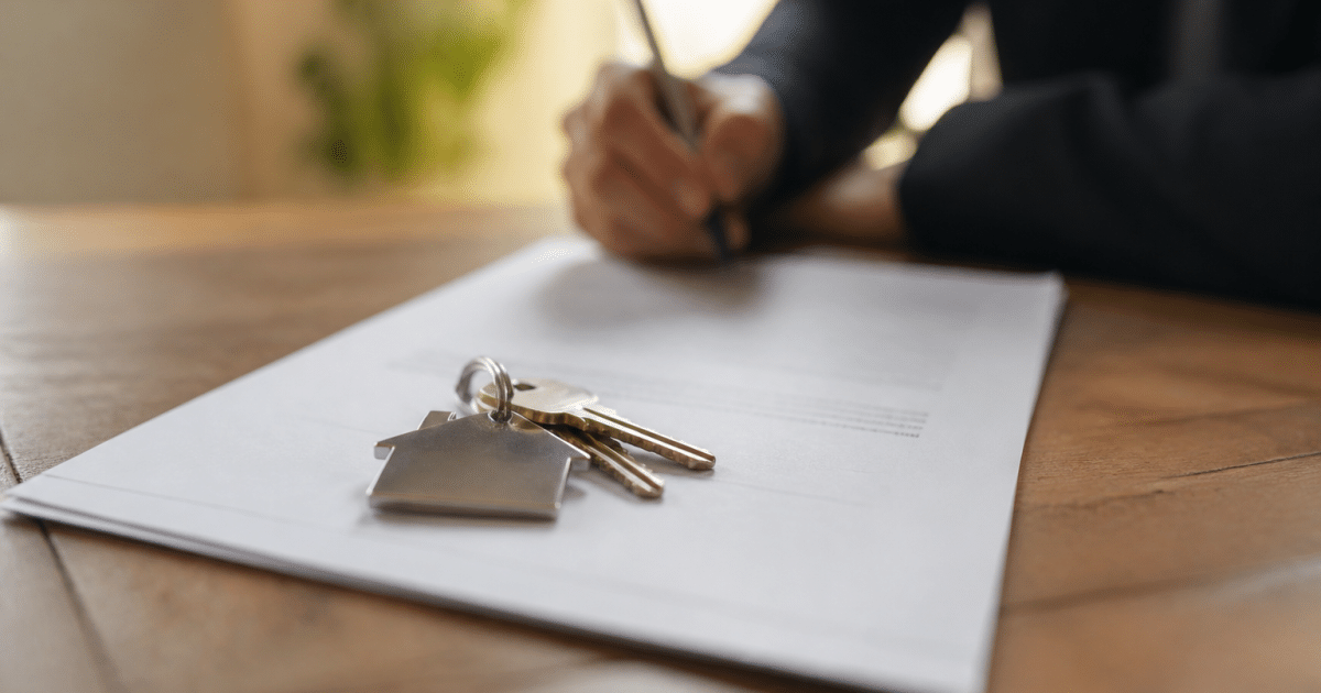 Contrat immobilier signe sur bureau avec cles maison posees dessus