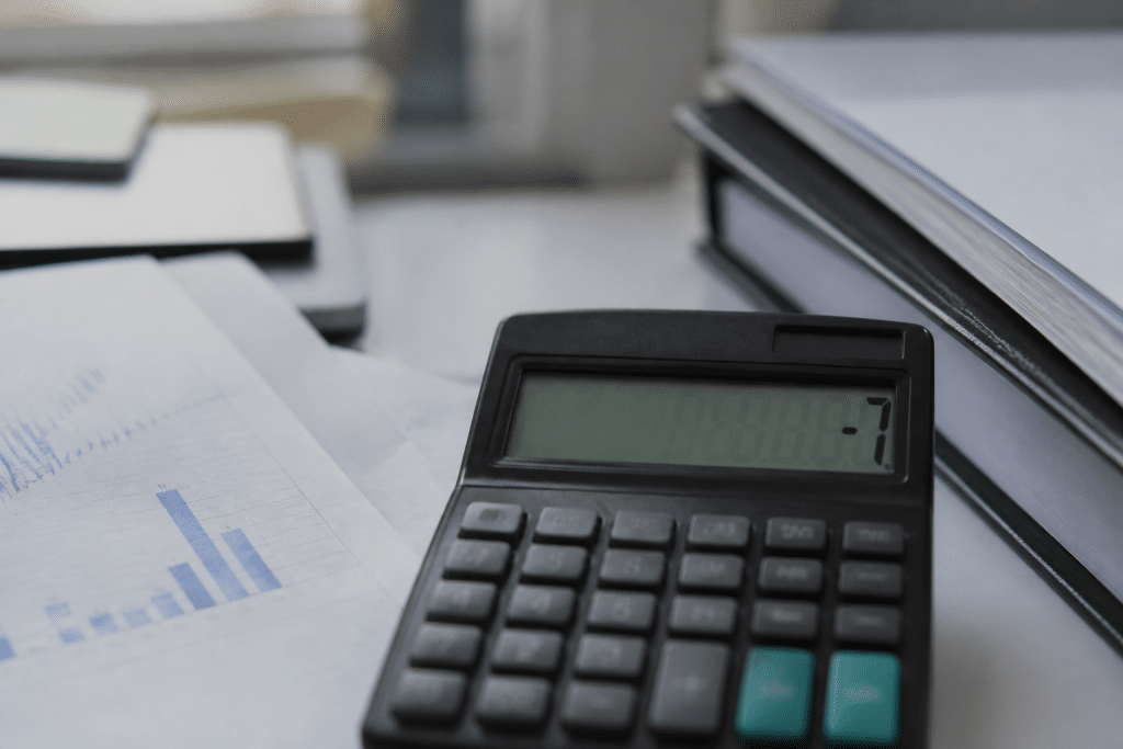 Calculatrice affichant chiffres négatifs près documents financiers