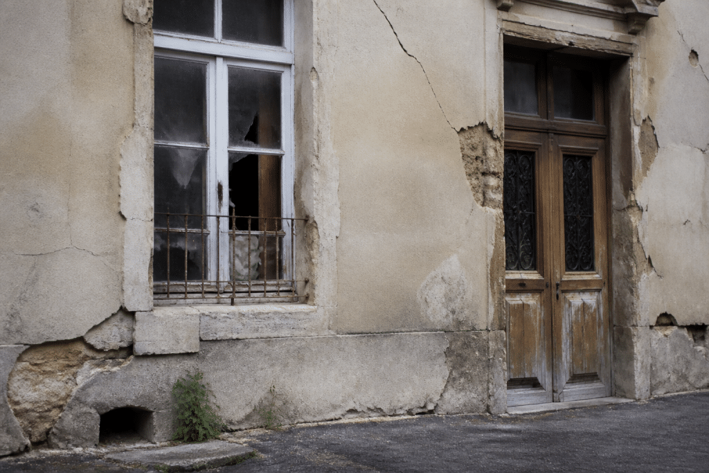 Immeuble ancien avec facade degradee et fissures visibles
