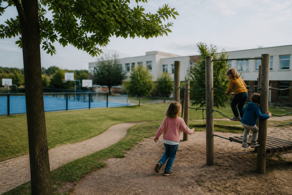 Parc avec enfants jouant près d'école et équipements sportifs