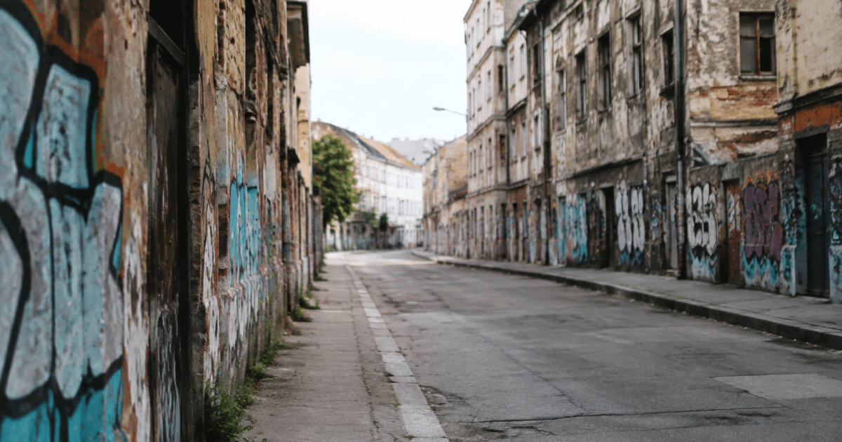 Rue urbaine déserte avec immeubles délabres et murs peints de graffitis