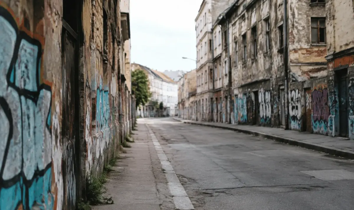 Rue urbaine déserte avec immeubles délabres et murs peints de graffitis