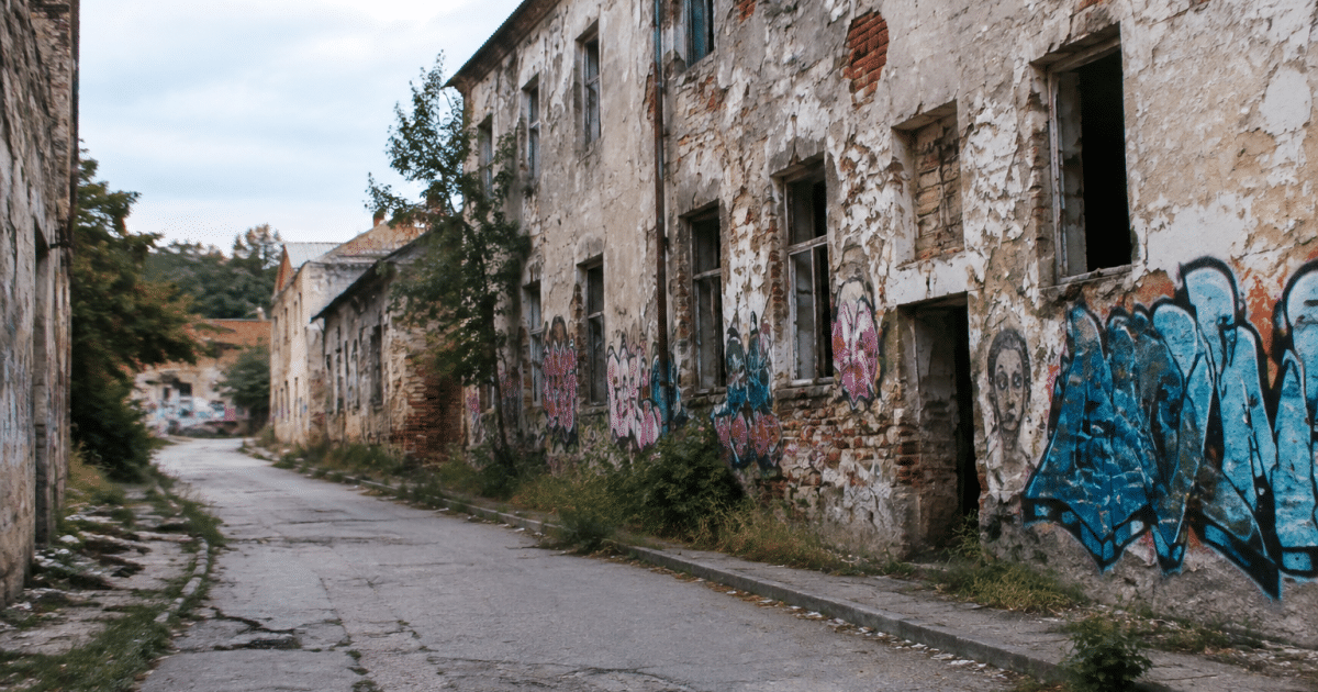 Rue urbaine dégradée avec bâtiments abandonnés et graffitis visibles