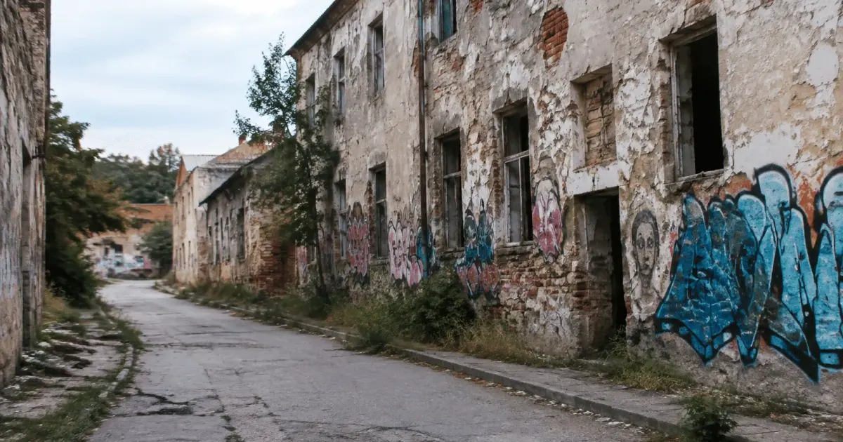 Rue urbaine dégradée avec bâtiments abandonnés et graffitis visibles