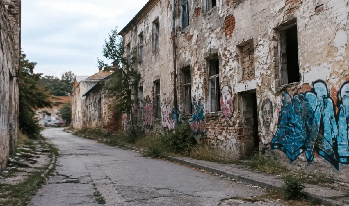 Rue urbaine dégradée avec bâtiments abandonnés et graffitis visibles