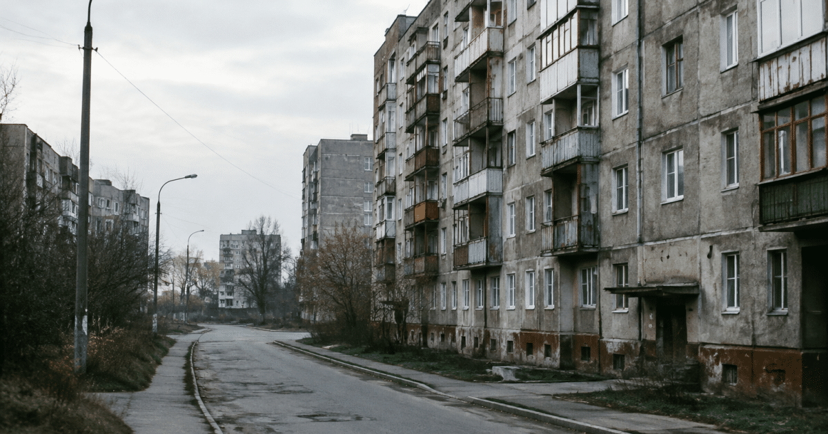 Rues urbaines delabrées avec immeubles gris surplombant routes vides