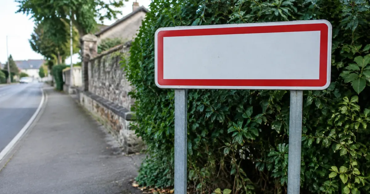 Panneau d'entree de ville au bord d'un trottoir